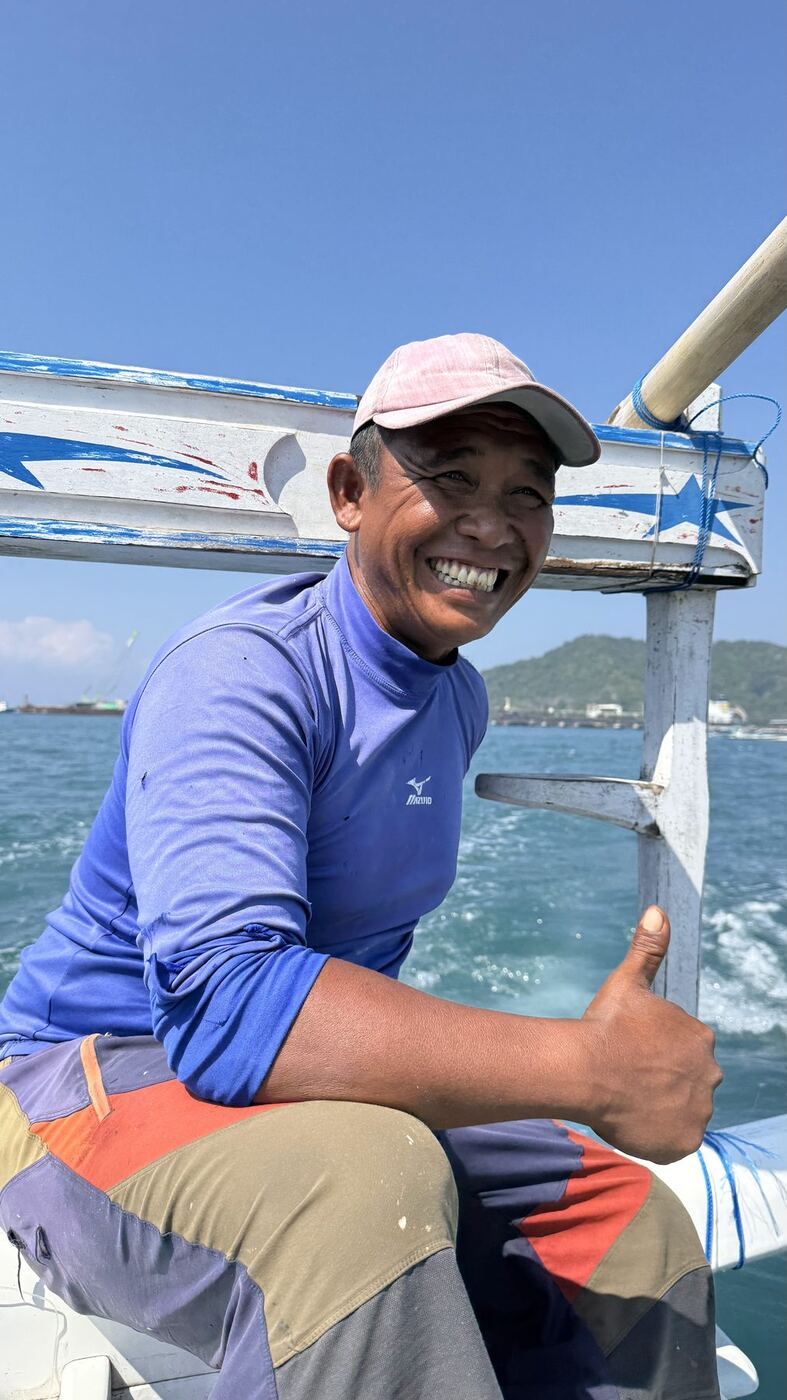 Pêcheur souriant à la barre du bateau